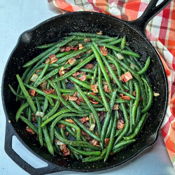 Green beans with bacon in a skillet.